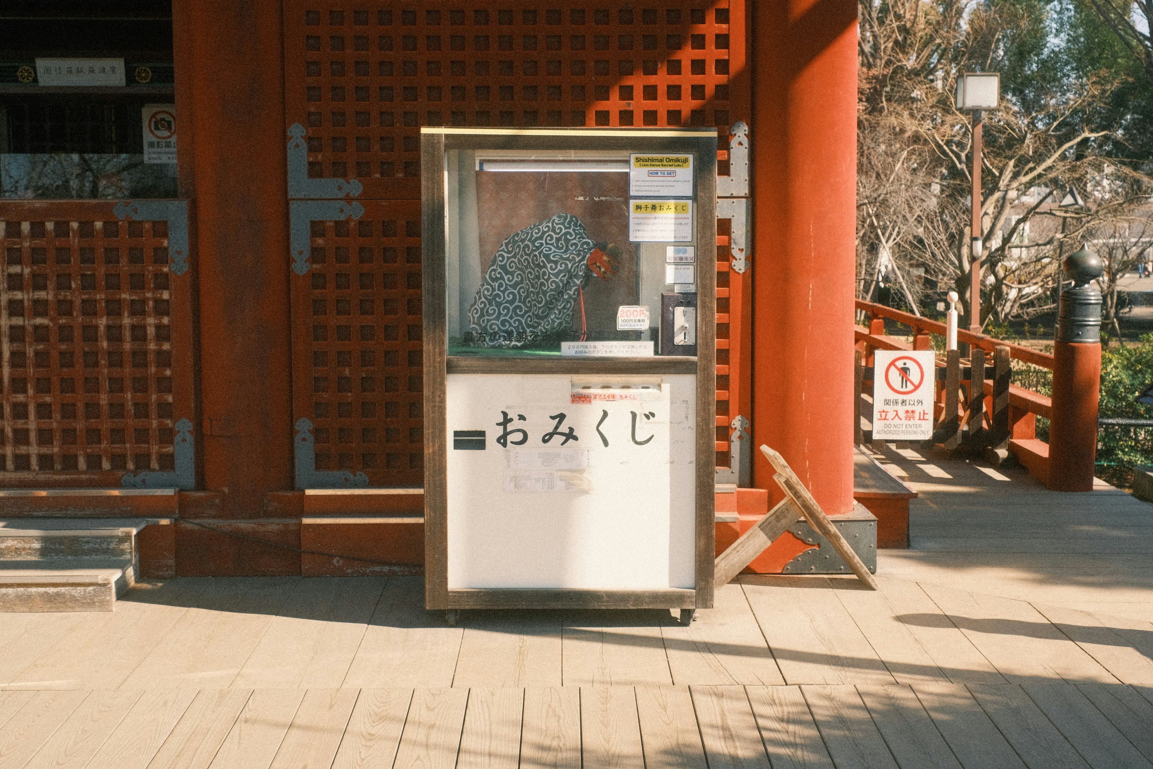 Macchina omikuji davanti a un edificio rosso