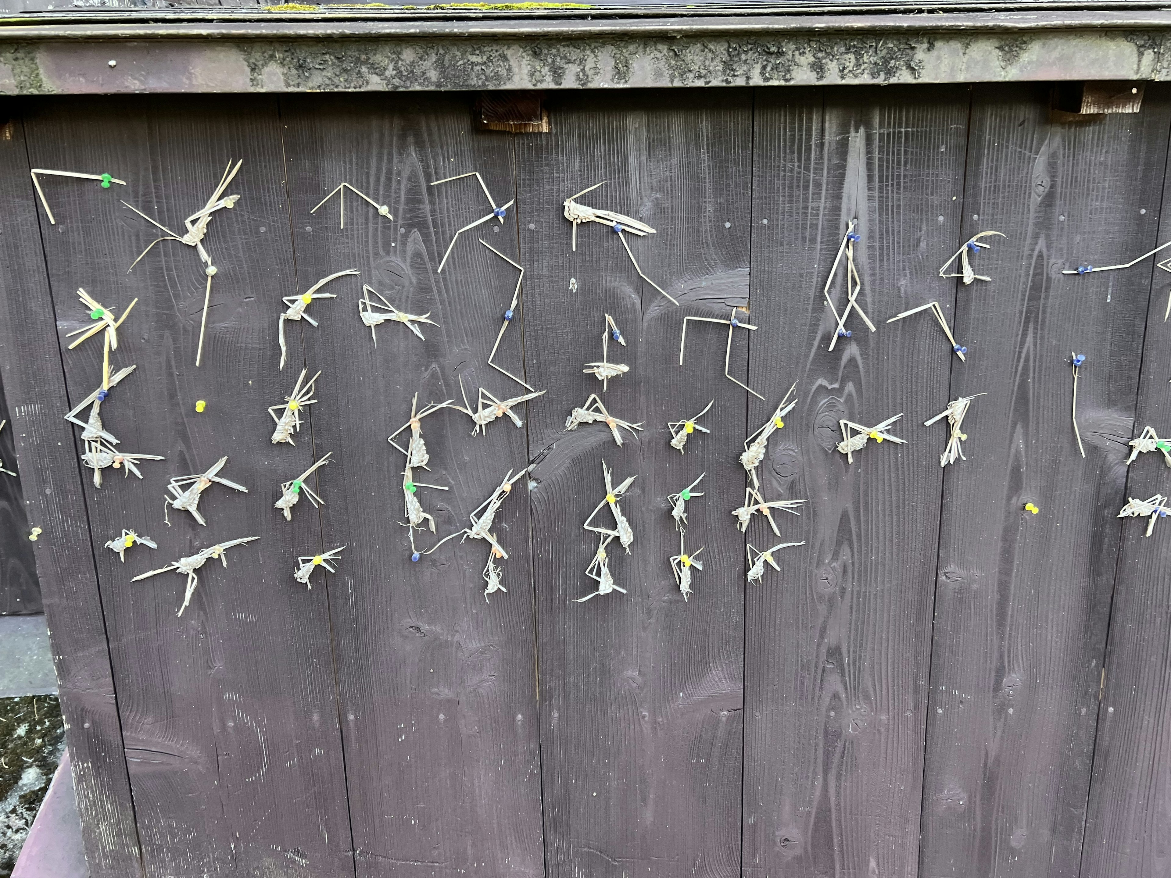 Figures made of thin sticks arranged on a wooden wall