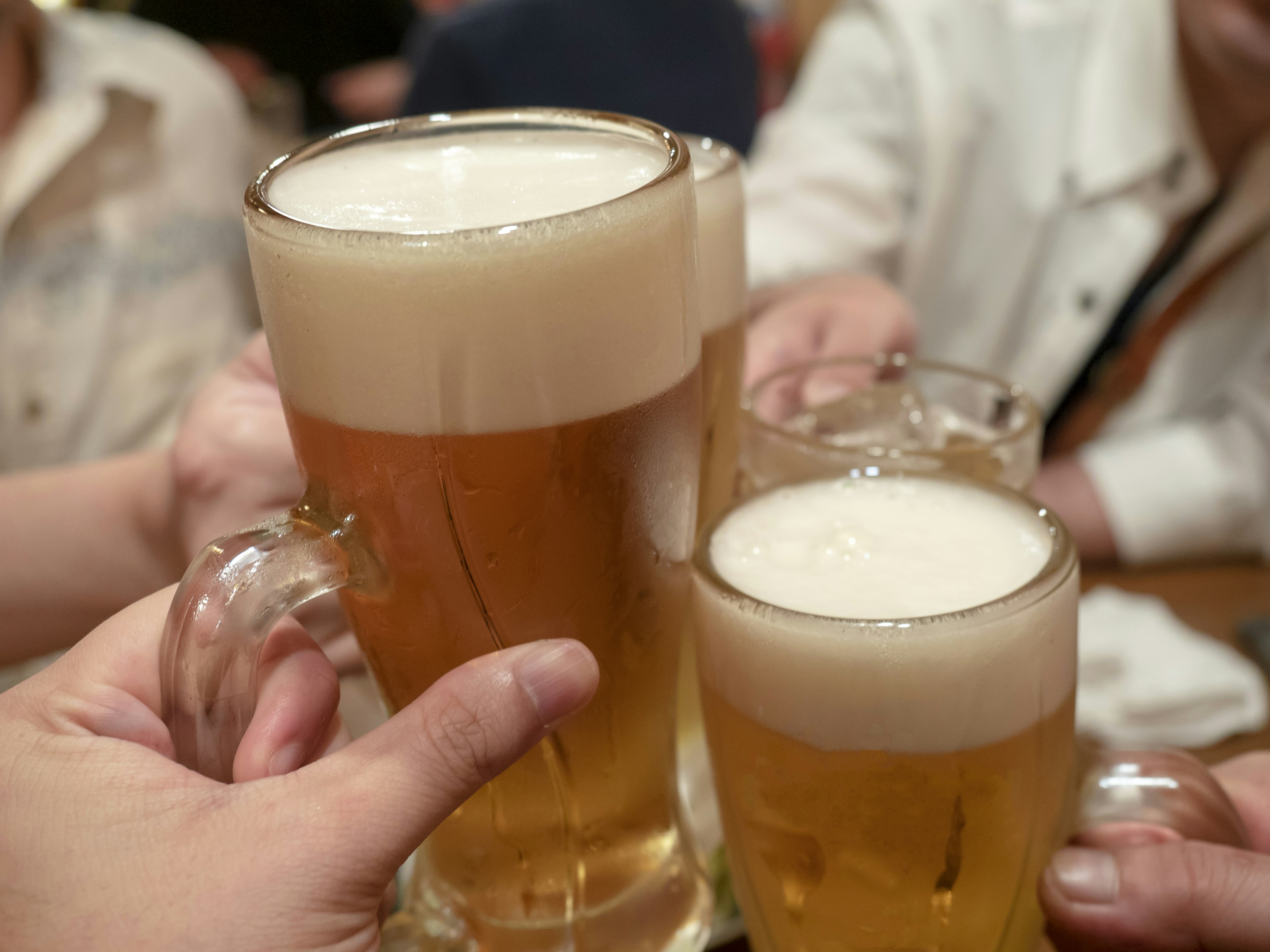 People clinking beer mugs in a celebratory toast