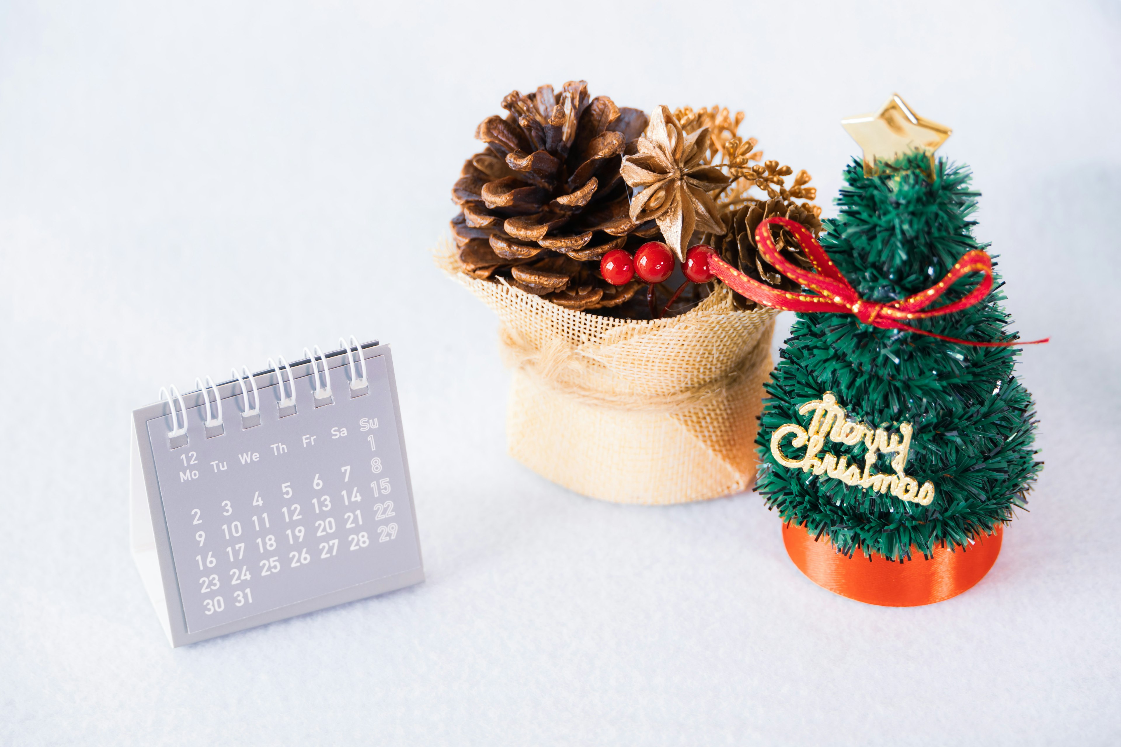 Un árbol de Navidad decorado y un arreglo de piñas sobre una mesa