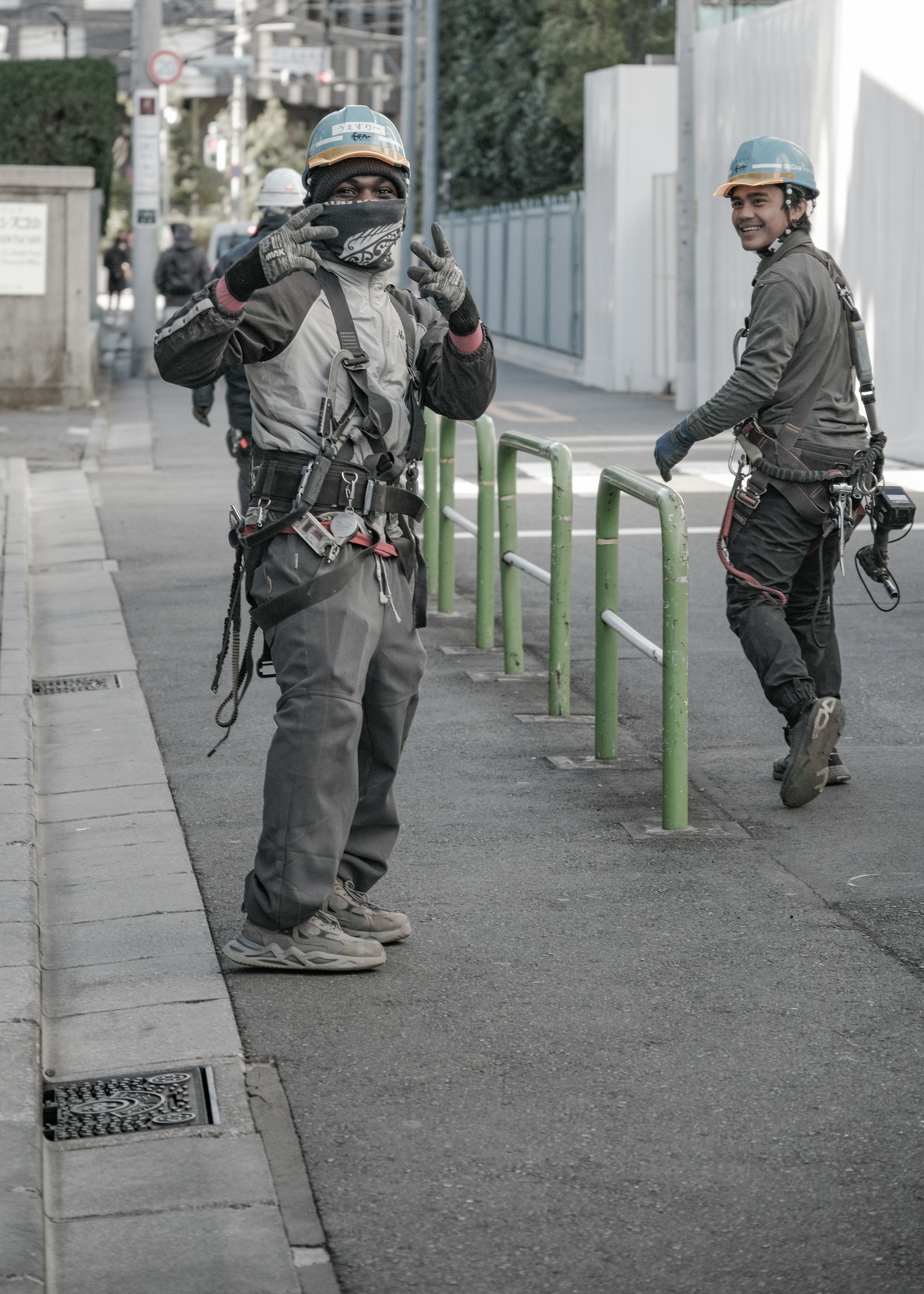 Two workers in safety gear on a city street