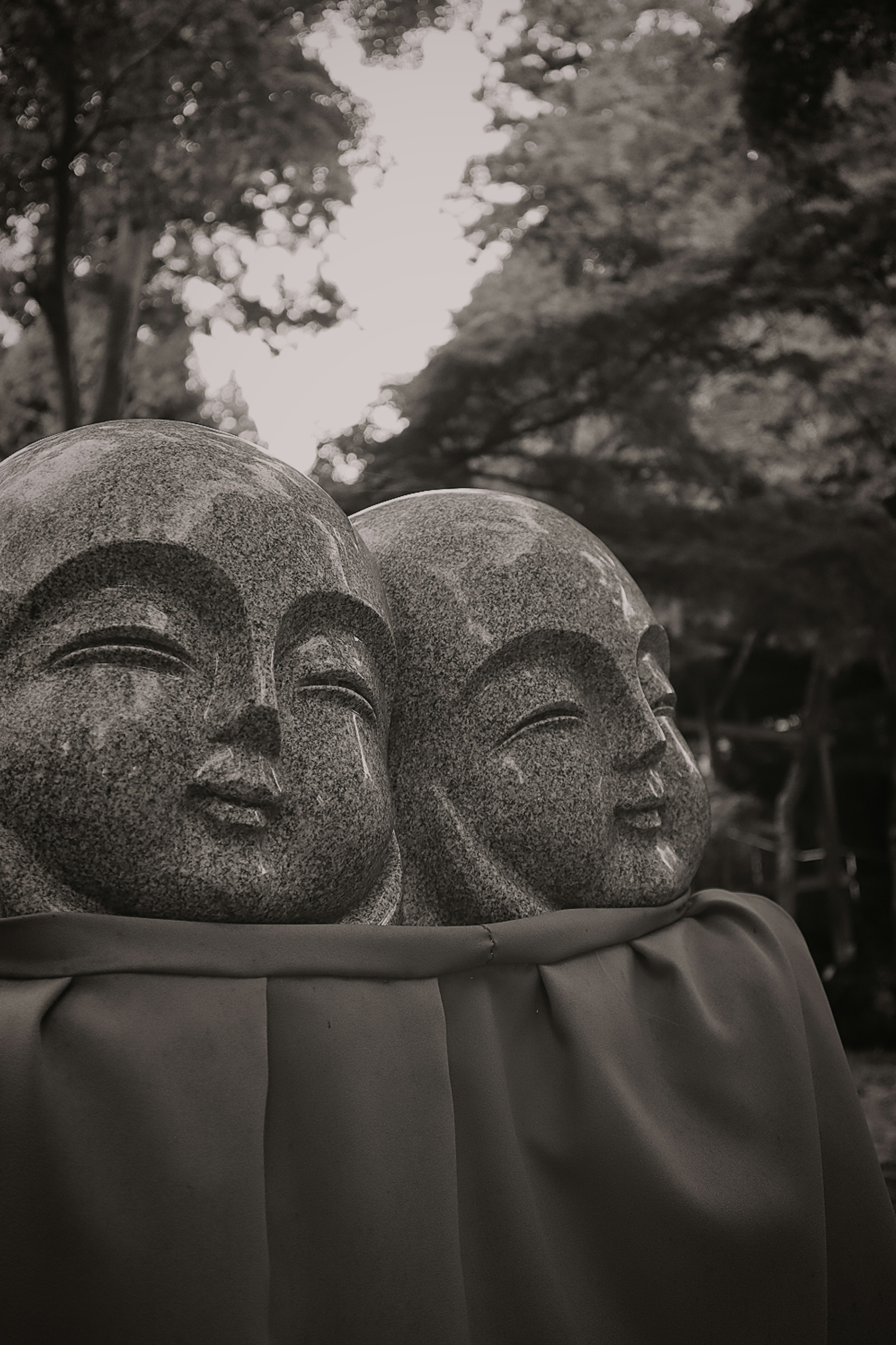 Two stone statues' faces smiling gently