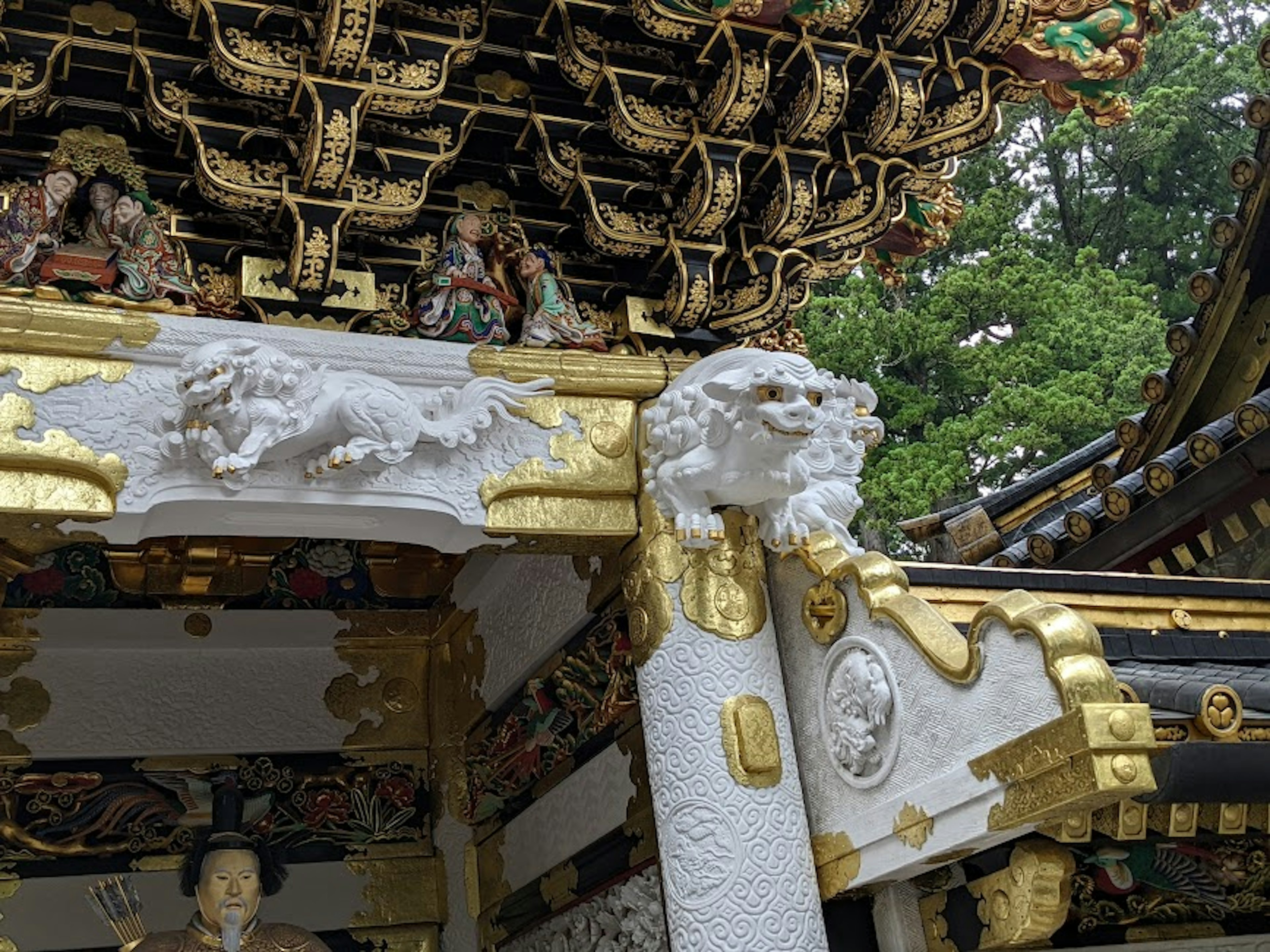 복잡한 장식이 있는 신사의 일부와 눈에 띄는 흰 사자 조각