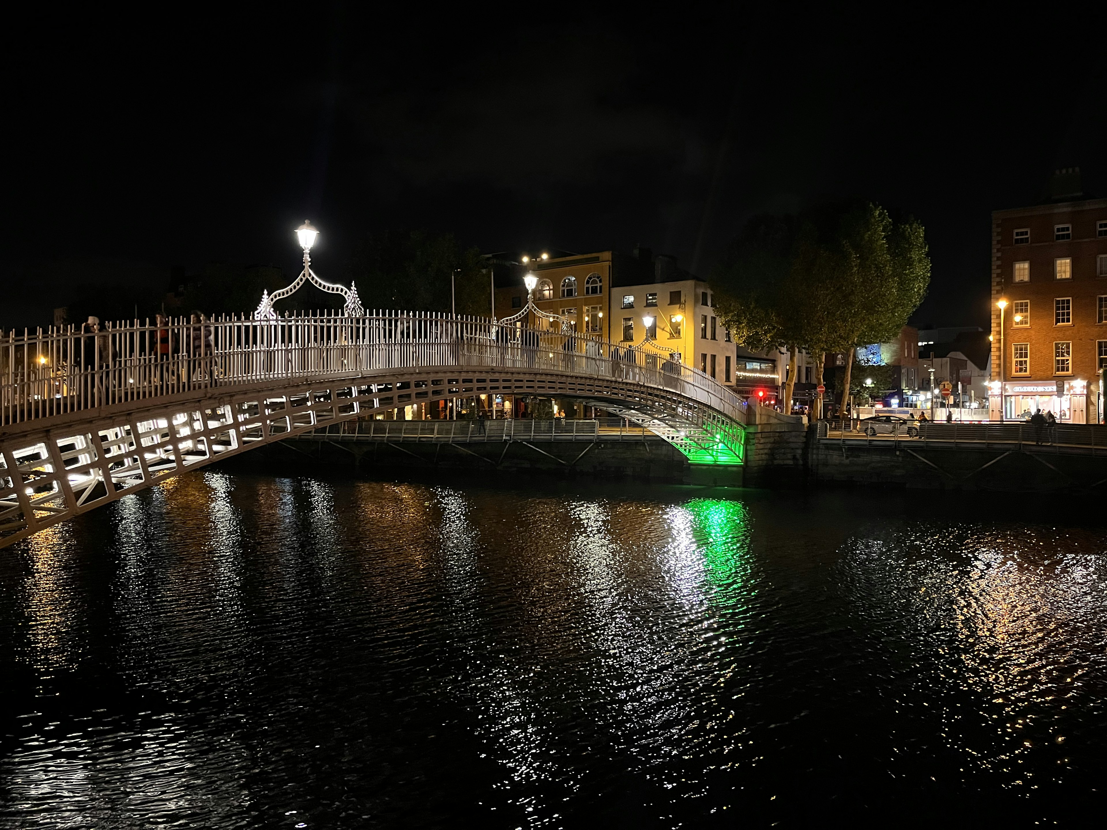 夜のダブリンのハーフペニー橋と周辺の建物の景色