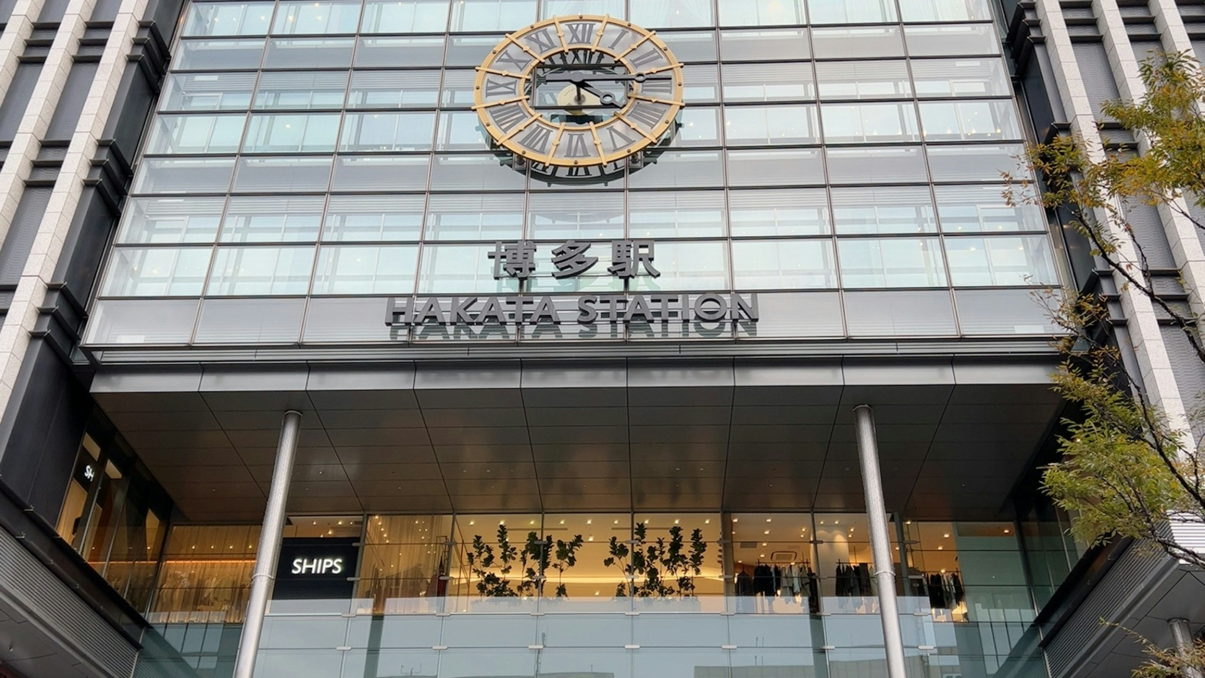 Modern facade of Takashimaya Station featuring a large clock and glass exterior