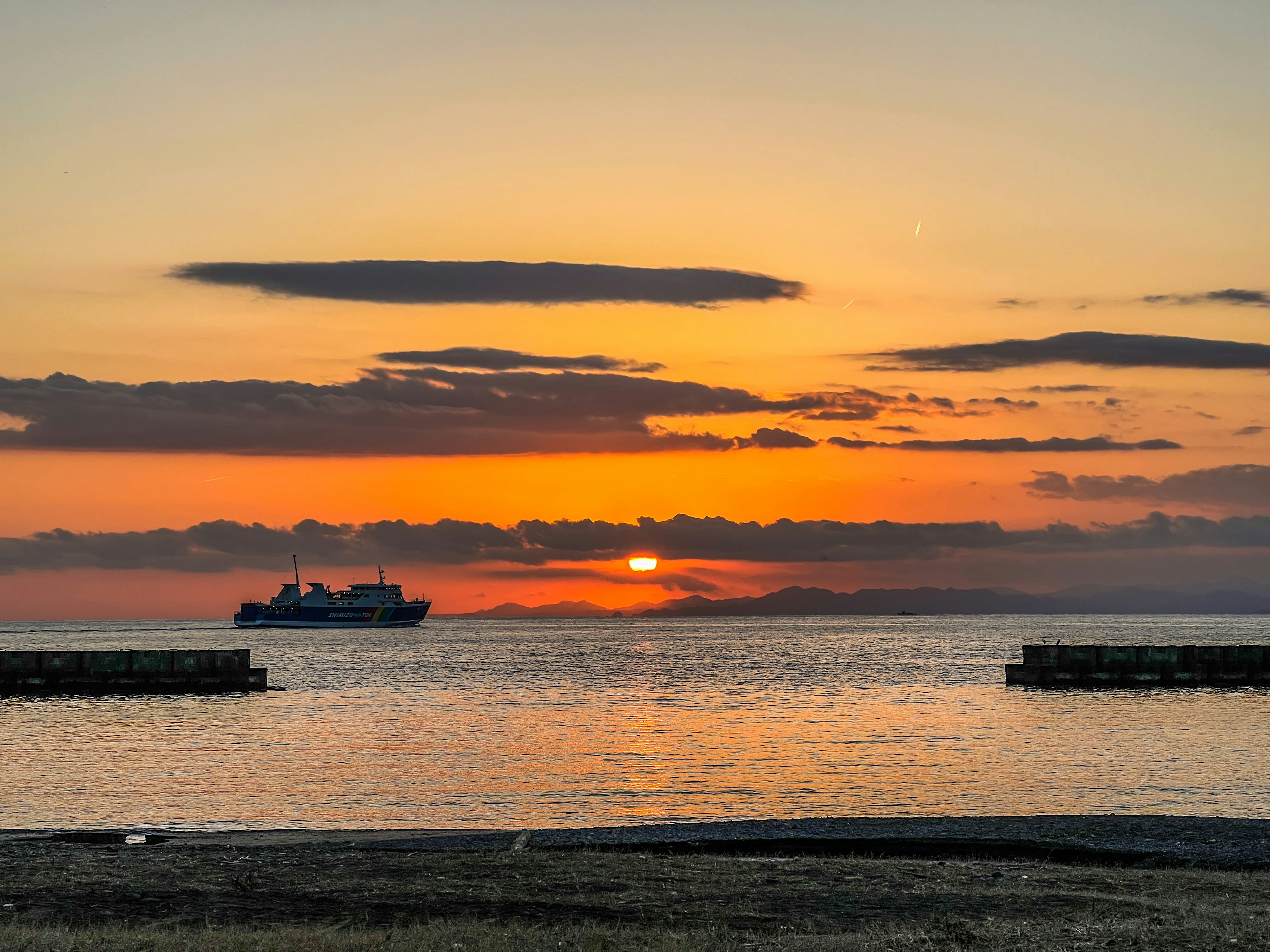 夕日が沈む海の景色に船が浮かぶ