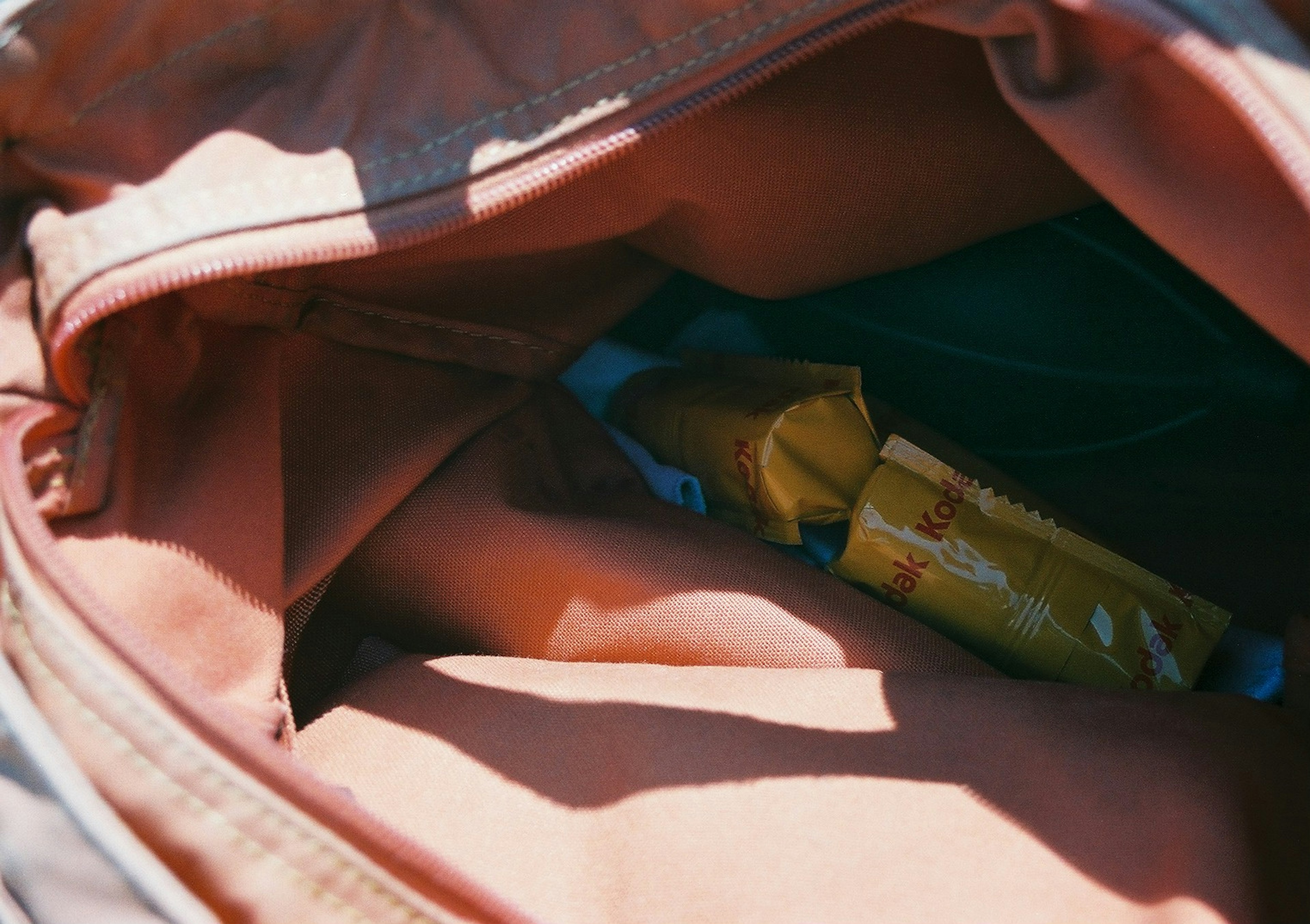 Interior de una mochila naranja mostrando un paquete amarillo