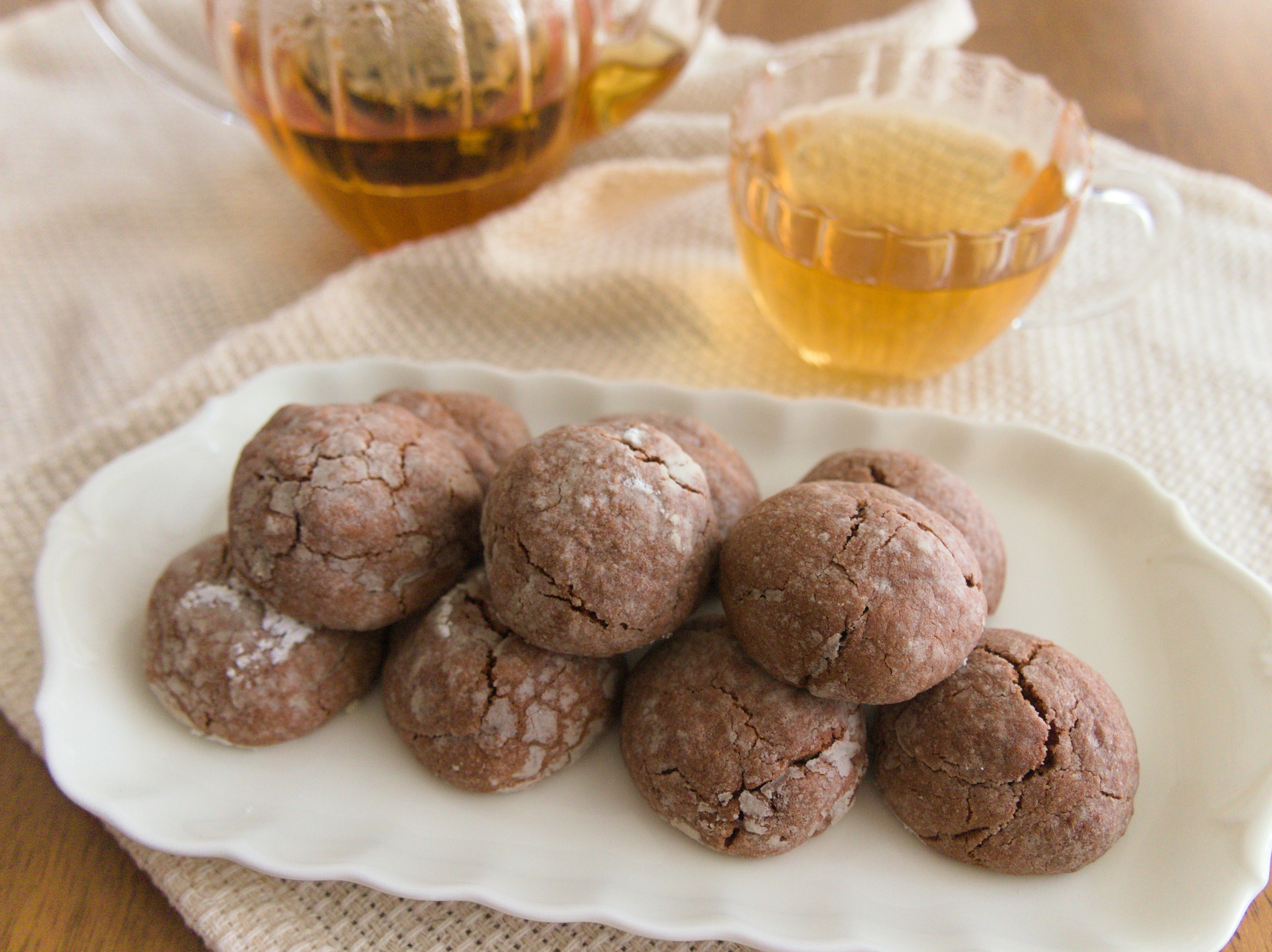 A beautiful arrangement of tea and cookies chocolate cookies on a silver plate with clear tea cups