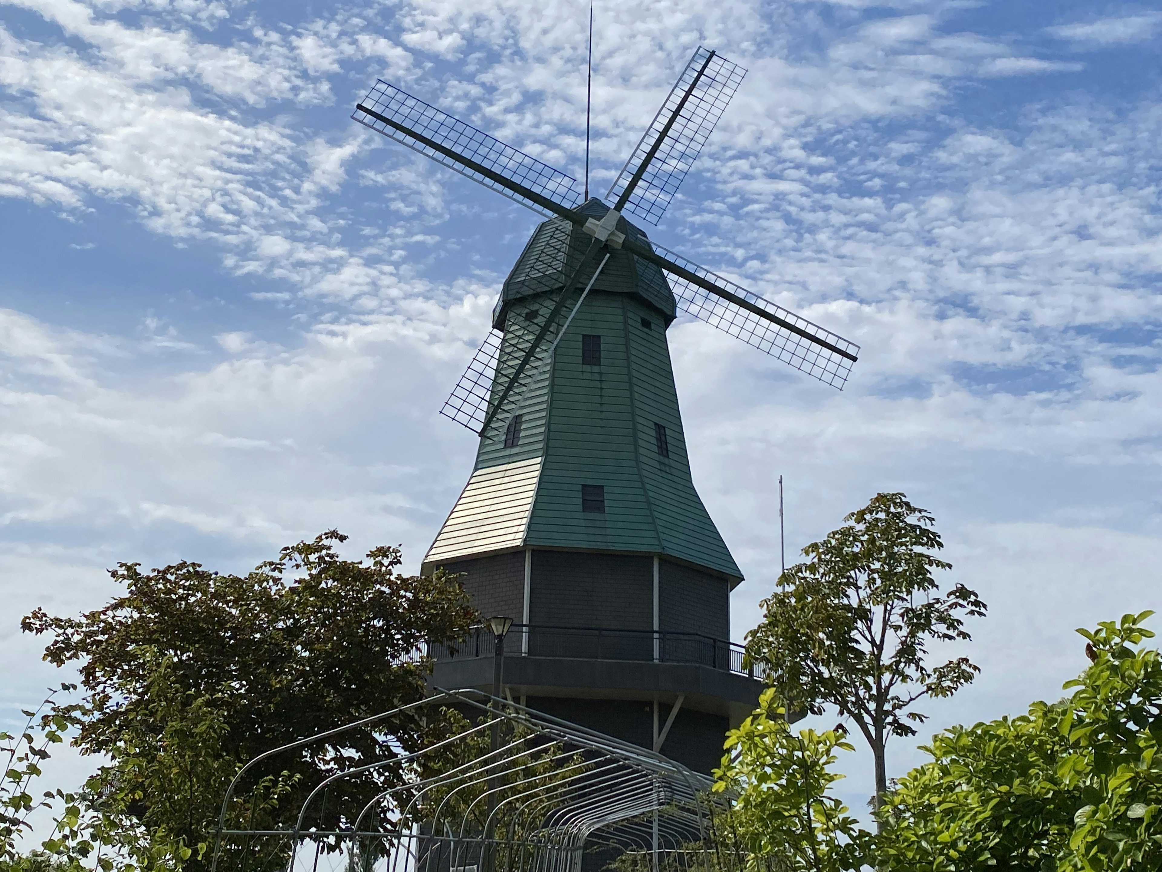 Green windmill standing under a blue sky