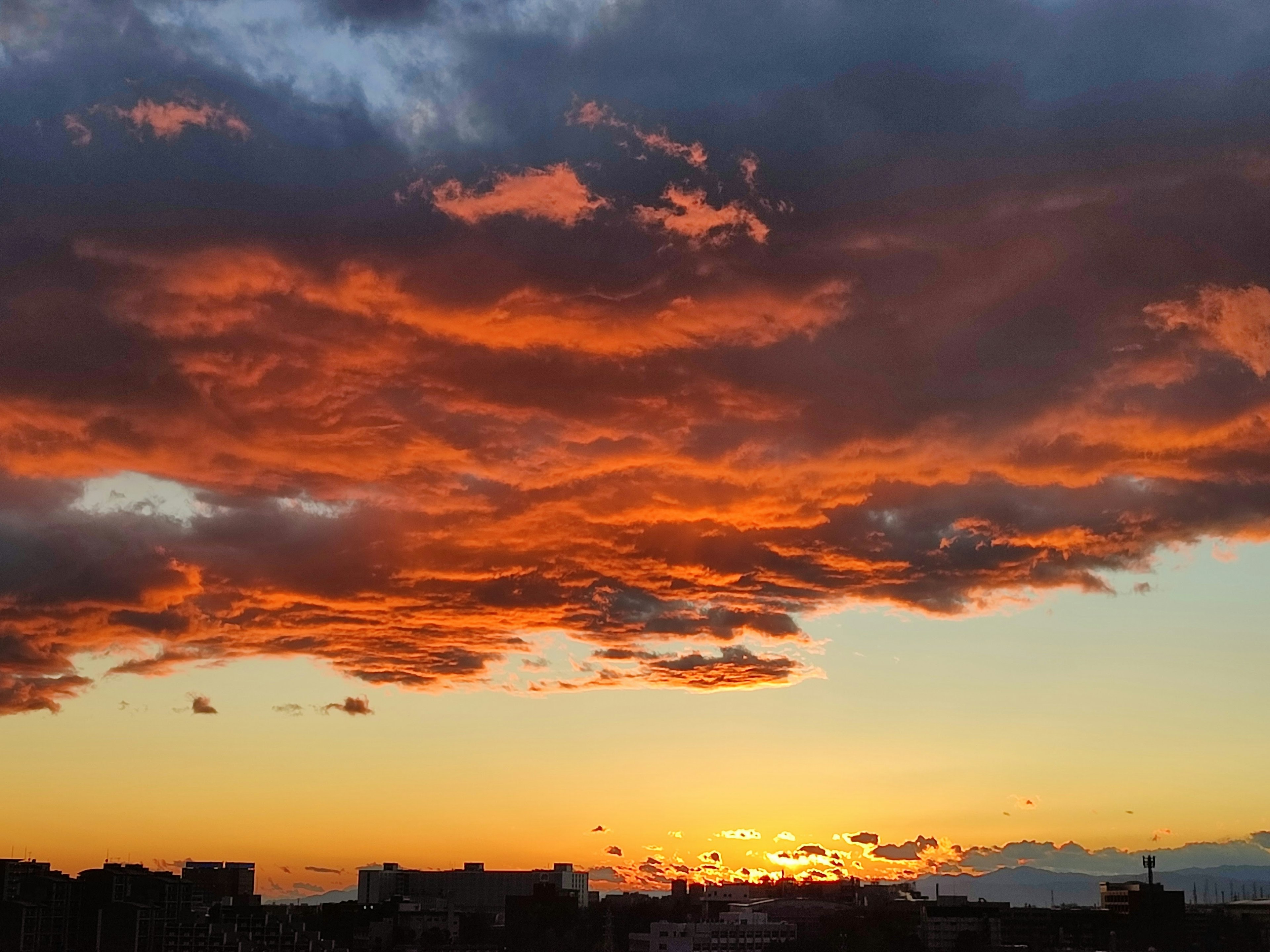 Nuages orange vif contre un ciel bleu au coucher du soleil